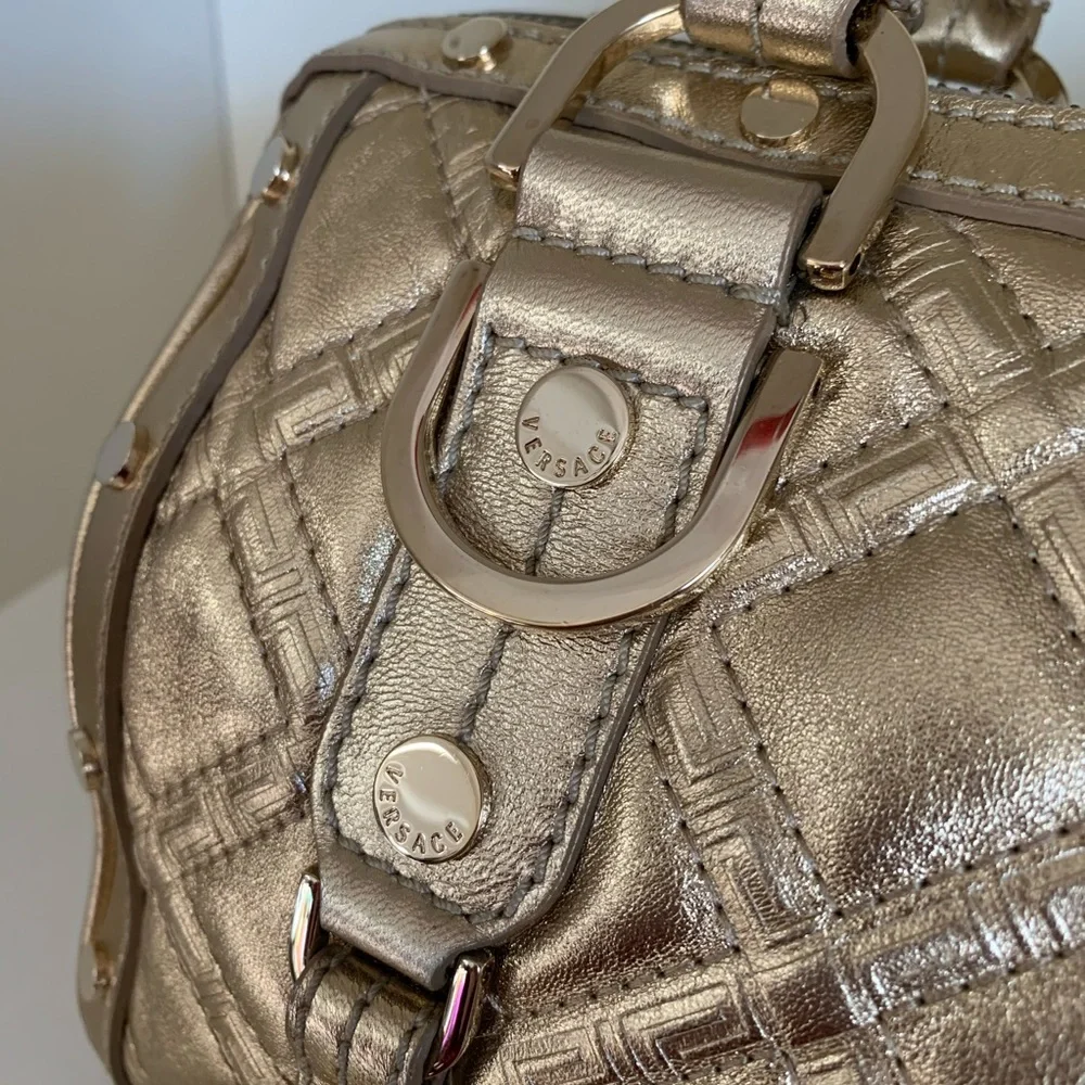 Hold Versace gold quilted handbag